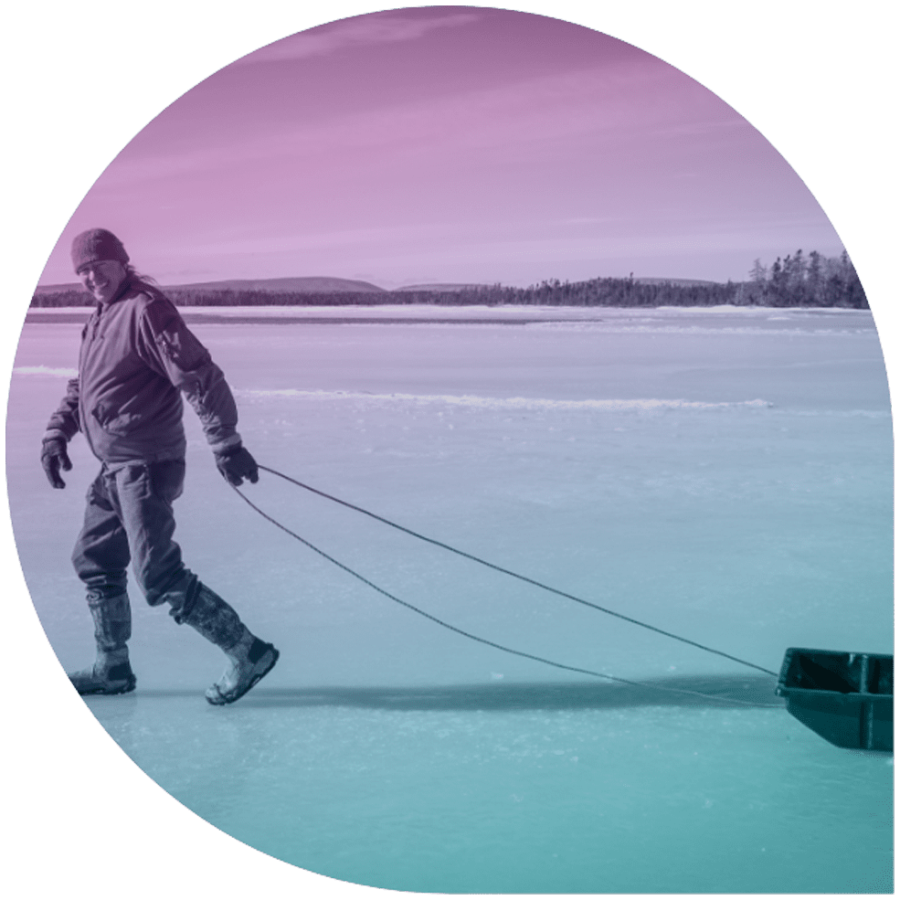 A man pulling a sled on a frozen lake